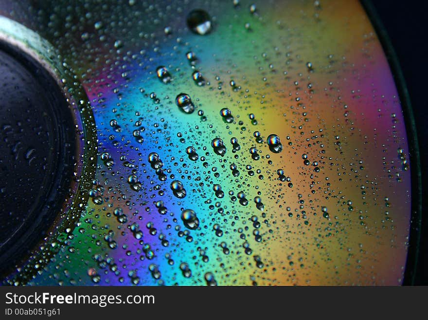 Shimmering CD with water drops and rainbow colors. Shimmering CD with water drops and rainbow colors