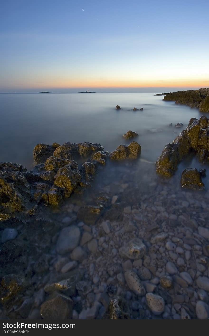 Rocks in the sea after sunset with blurry water. Rocks in the sea after sunset with blurry water