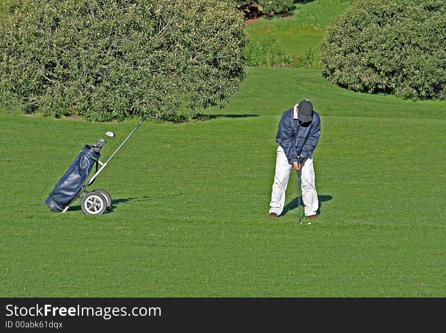 Golfer and caddy bag on the course