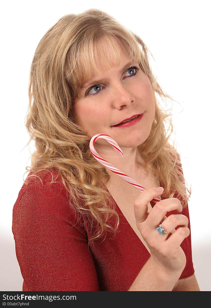 Beautiful blond Caucasian woman eating a candy cane. Beautiful blond Caucasian woman eating a candy cane.