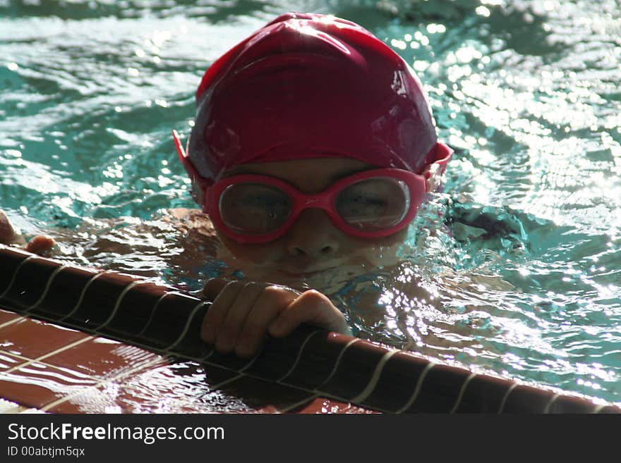 Little girl in the side of the pool getting ready to swim. Little girl in the side of the pool getting ready to swim.