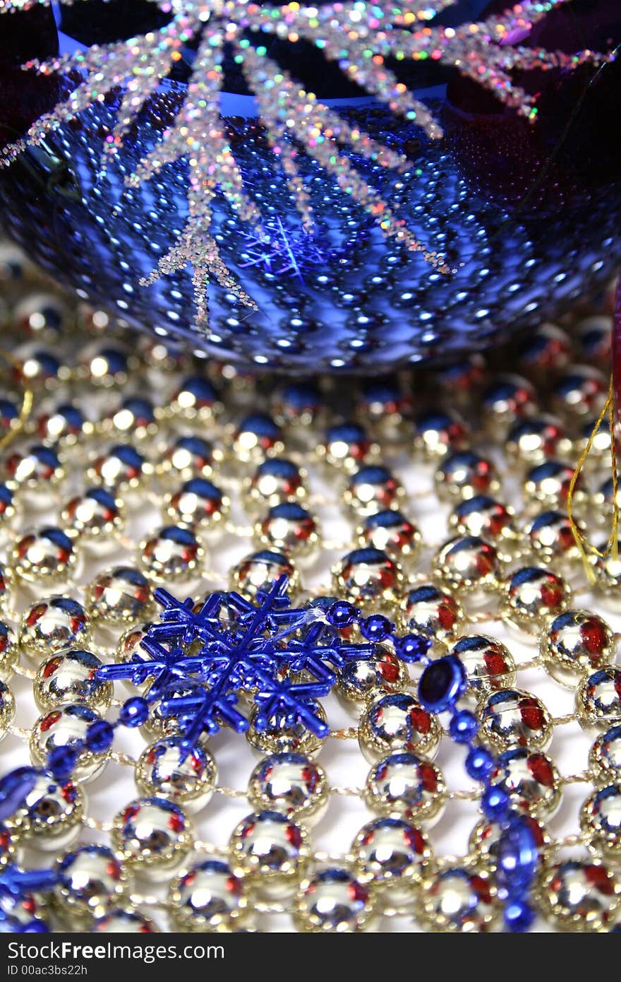 Glass christmas sphere and snowflake of dark blue color on a background made of a beads