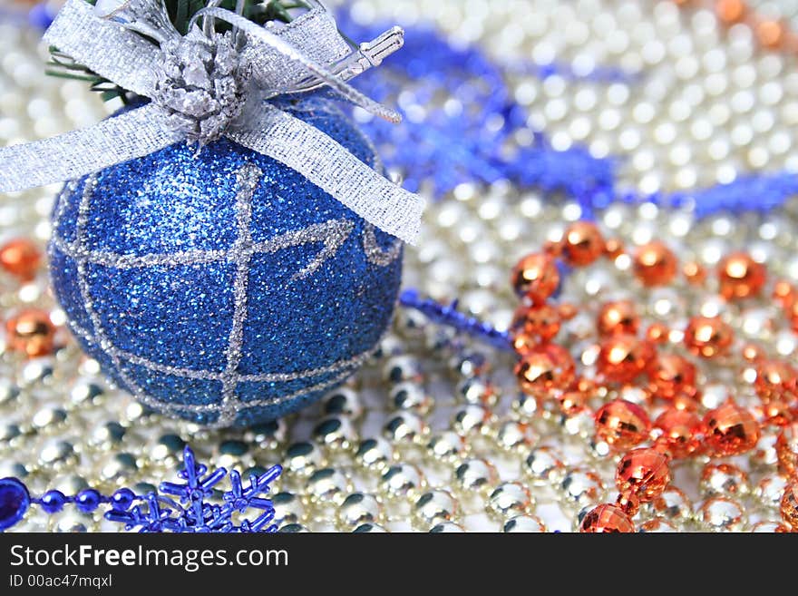 Christmas sphere of dark blue color with a pattern on a background of a multi-coloured beads