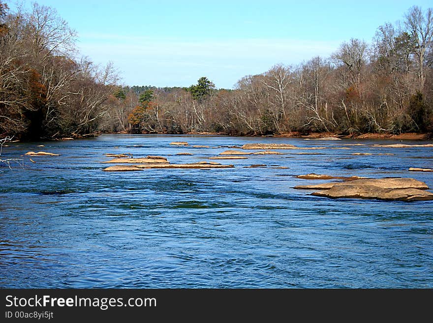 Calm blue river flowing past rocks in wilderness area