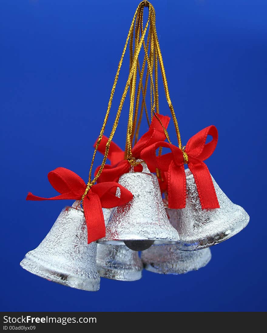 Christmas celebratory handbells of silvery color on a dark blue background. Christmas celebratory handbells of silvery color on a dark blue background