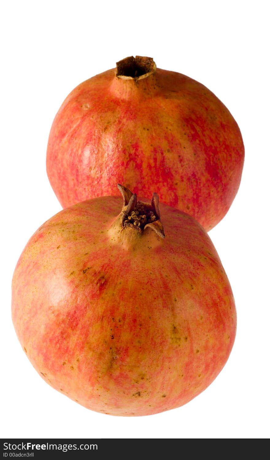 Two pomegranates isolated on white background, vertically disposed. Two pomegranates isolated on white background, vertically disposed