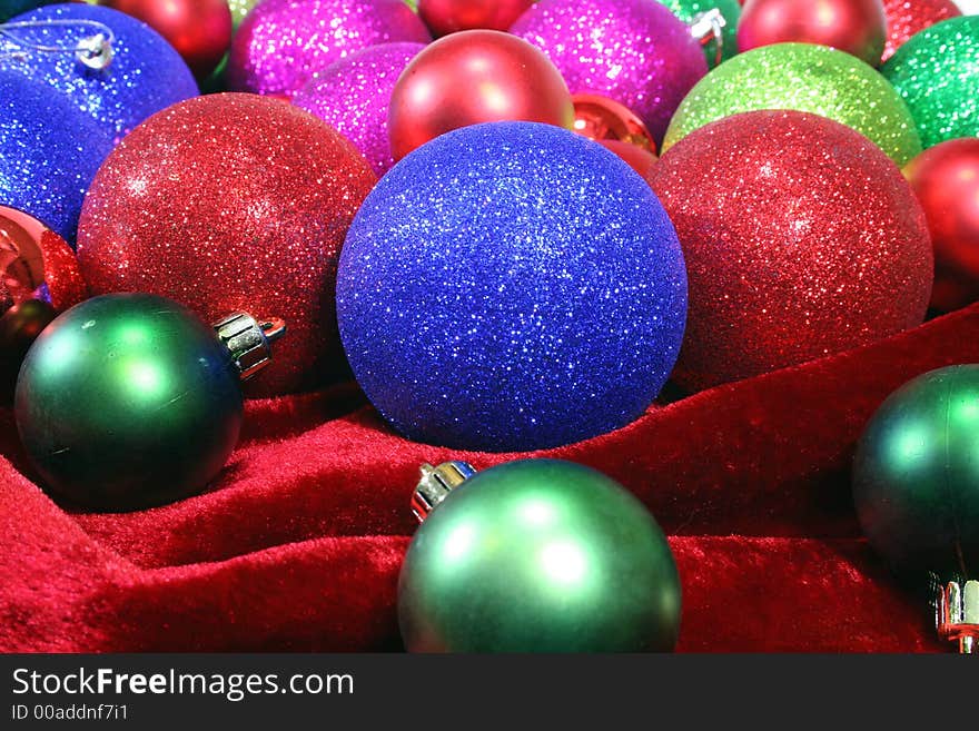 Christmas ornaments of all sizes and textures on red velvet. Christmas ornaments of all sizes and textures on red velvet