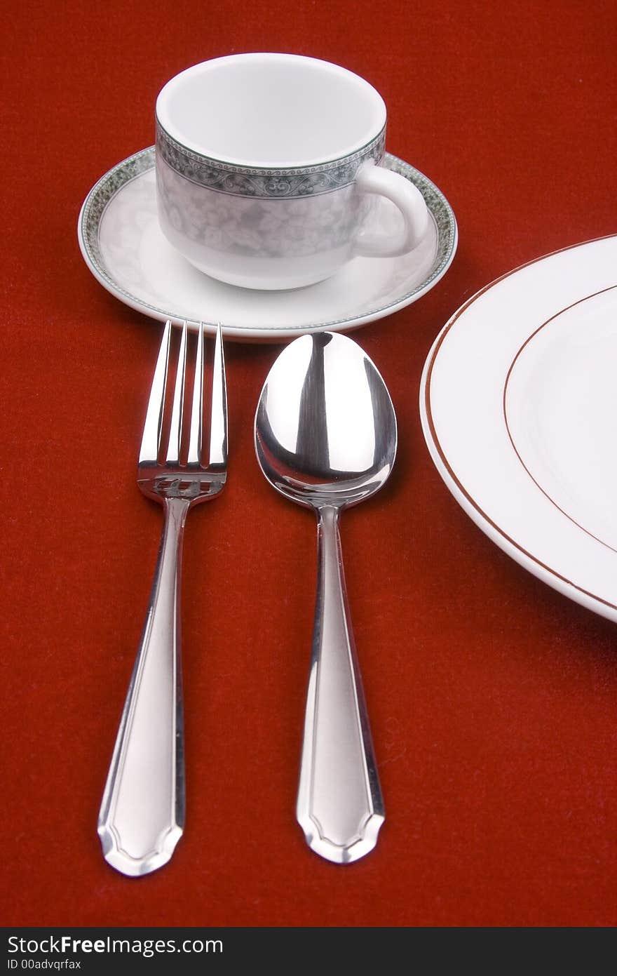 Place setting of a dinning set in red background.