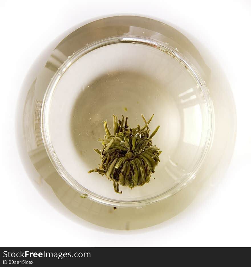 A glass of artisan blooming tea on white