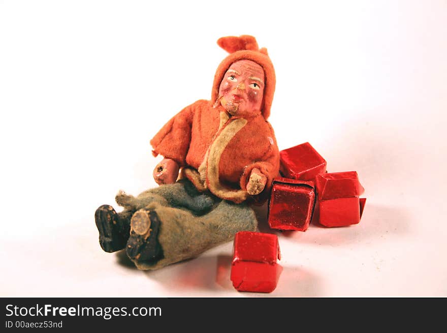 Antique elf with red presents over white background. Antique elf with red presents over white background