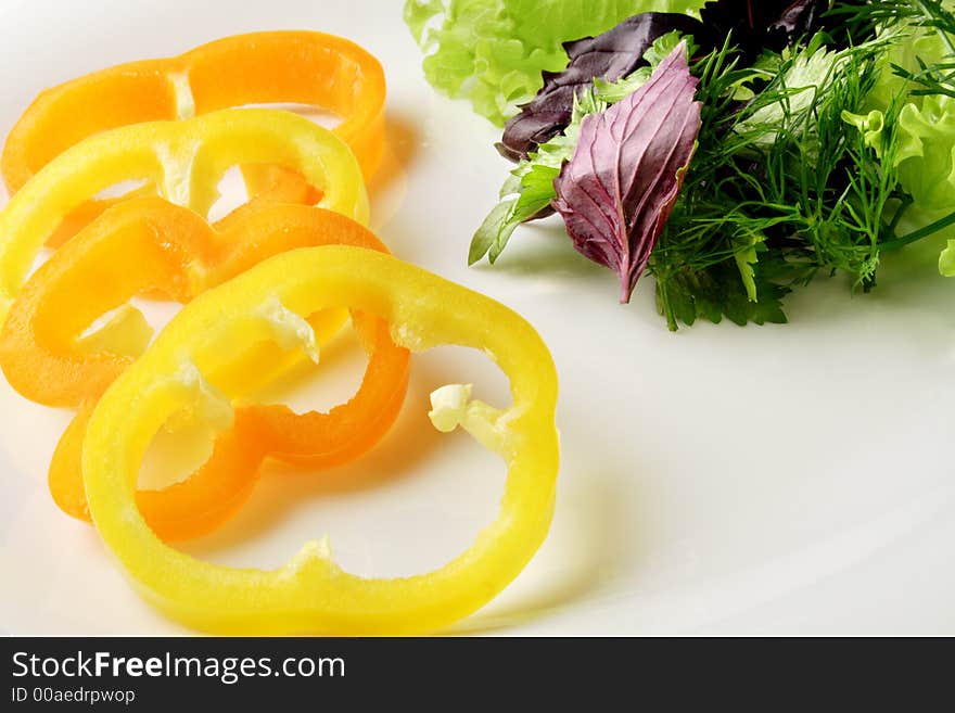 Slised paprika whith herbs on white plate. Slised paprika whith herbs on white plate