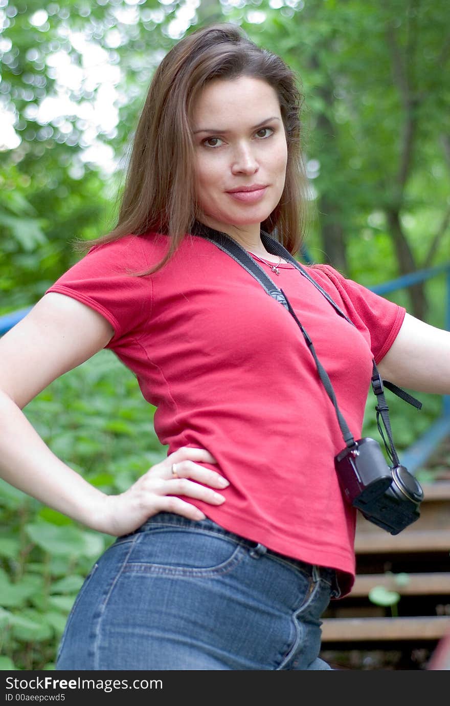 Beautiful lady on a vocation posing with camera against her neck. Beautiful lady on a vocation posing with camera against her neck