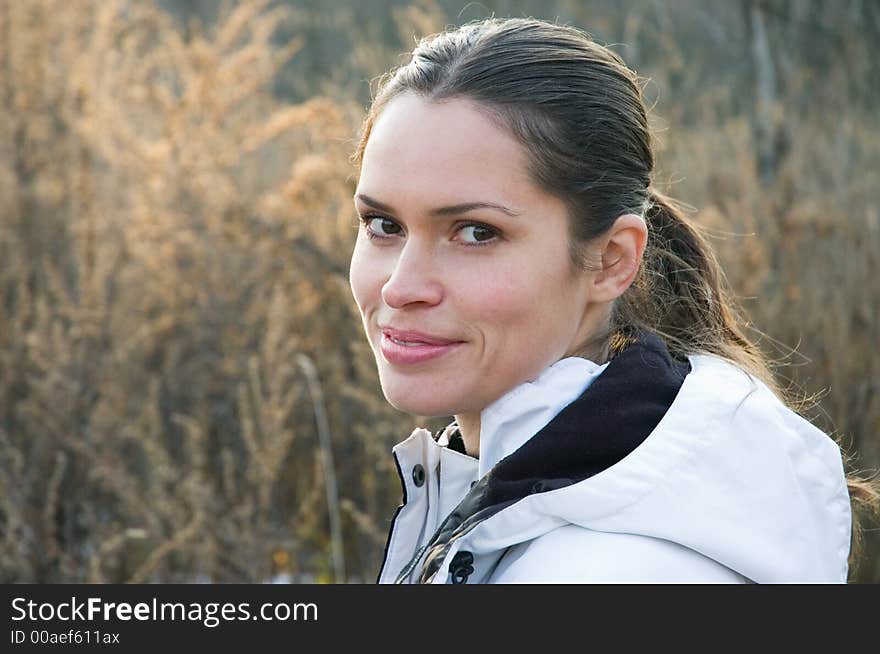 Woman in a white wind coat against autumn field. Woman in a white wind coat against autumn field