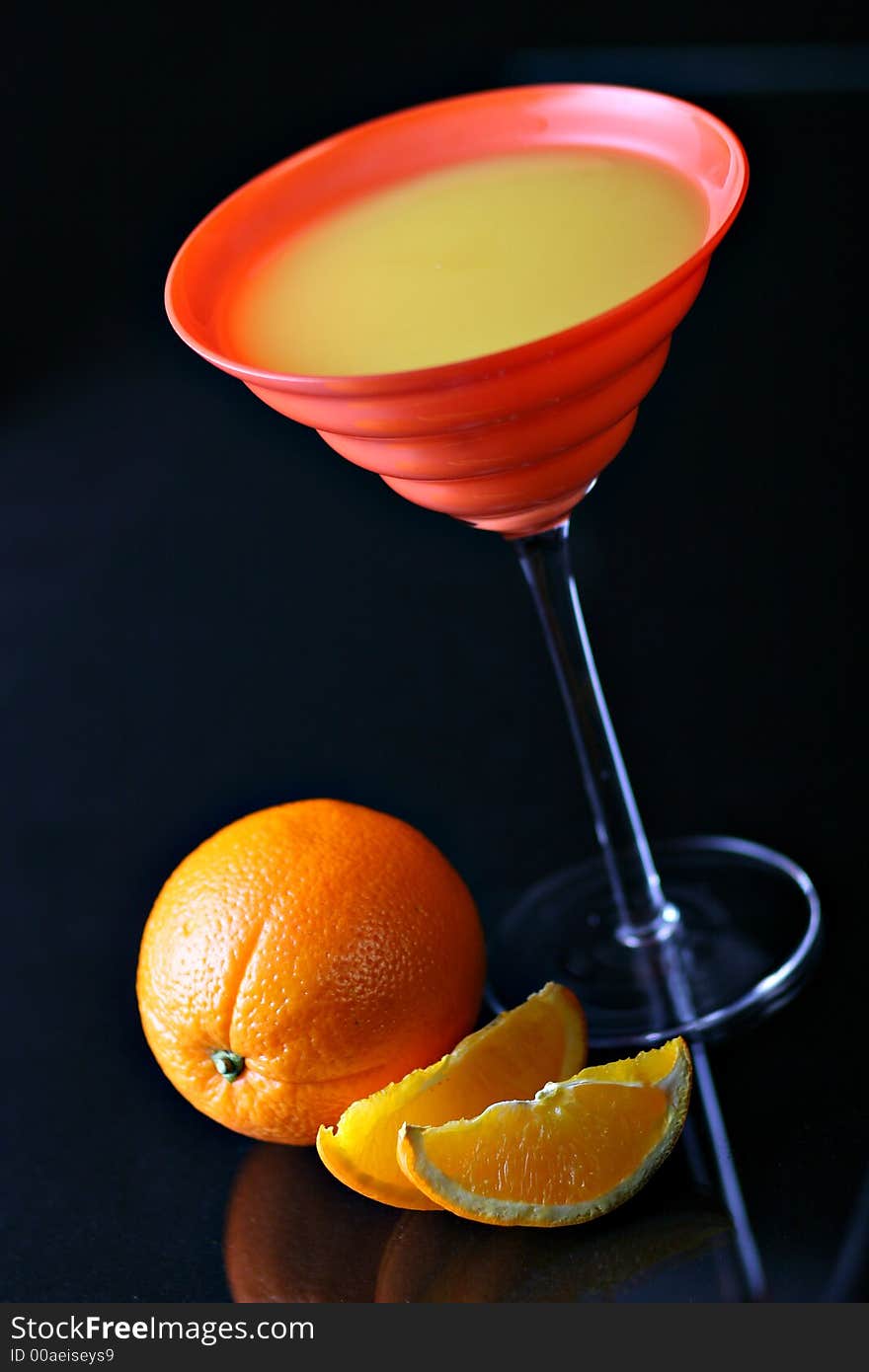 Orange juice in orange glass with oranges on background, on black, with reflections. Orange juice in orange glass with oranges on background, on black, with reflections