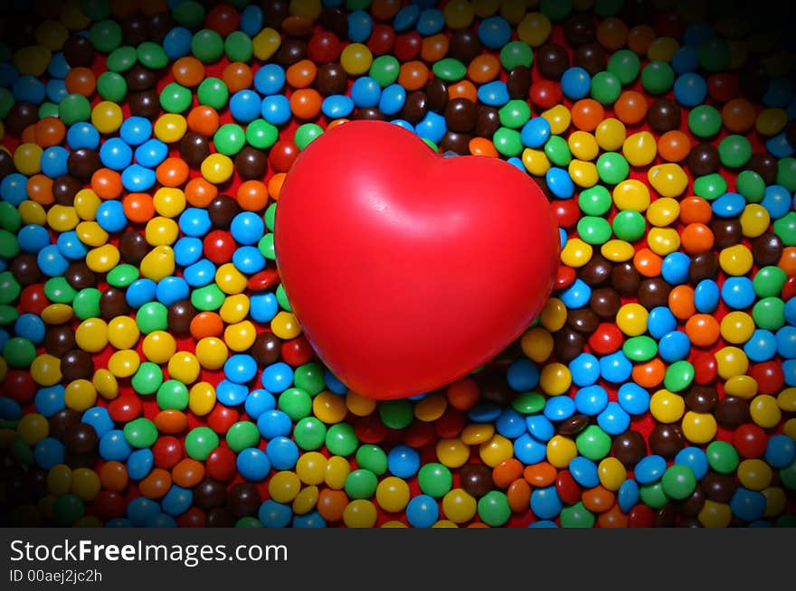 Soft red heart over candy background