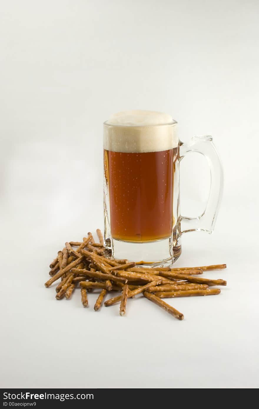 A mug of frosty beer and pretzels