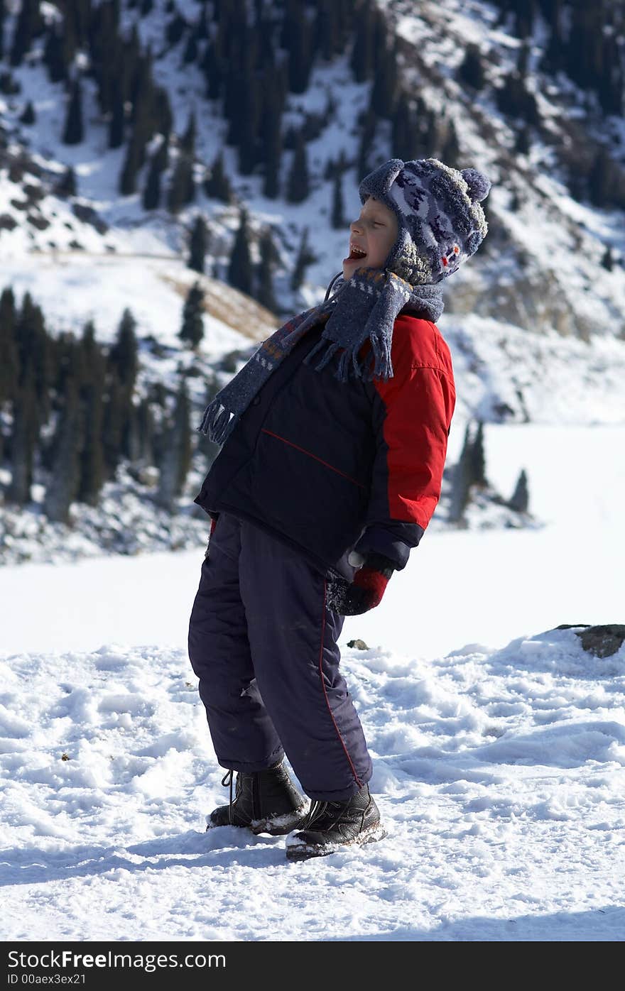 Laughing boy in winter mountain