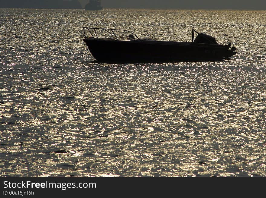 A lone vessel in the sea remains motionless under the burning sun