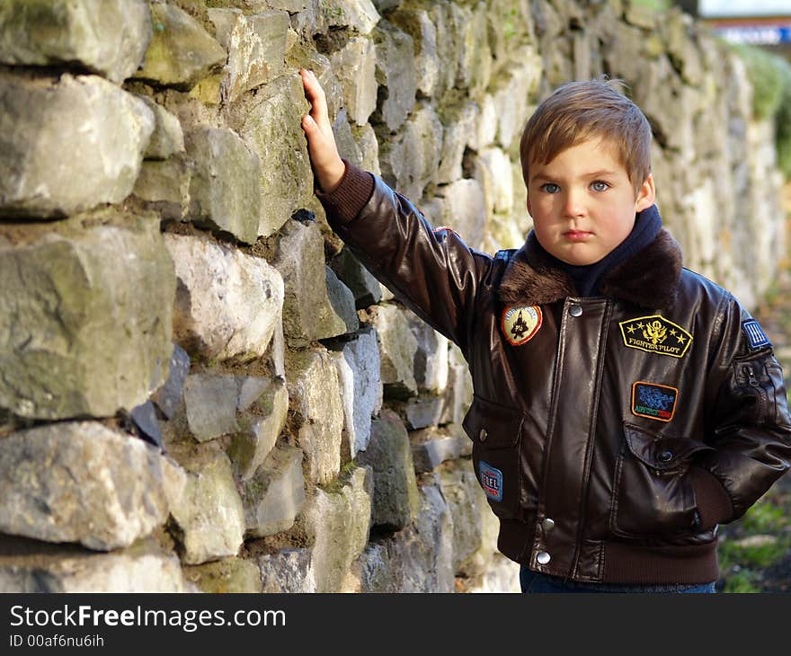 Boy standing on the stones wall