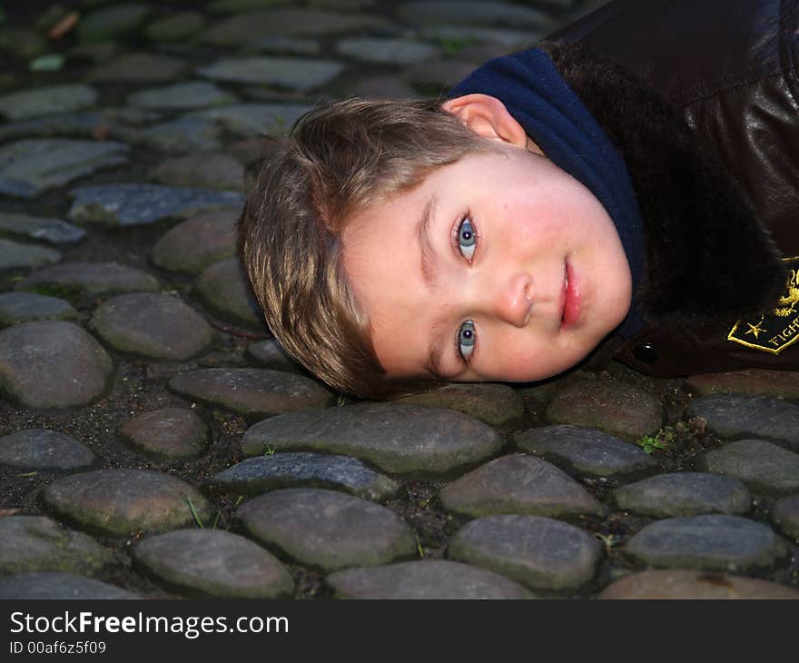 Boy sleeping on the stones way