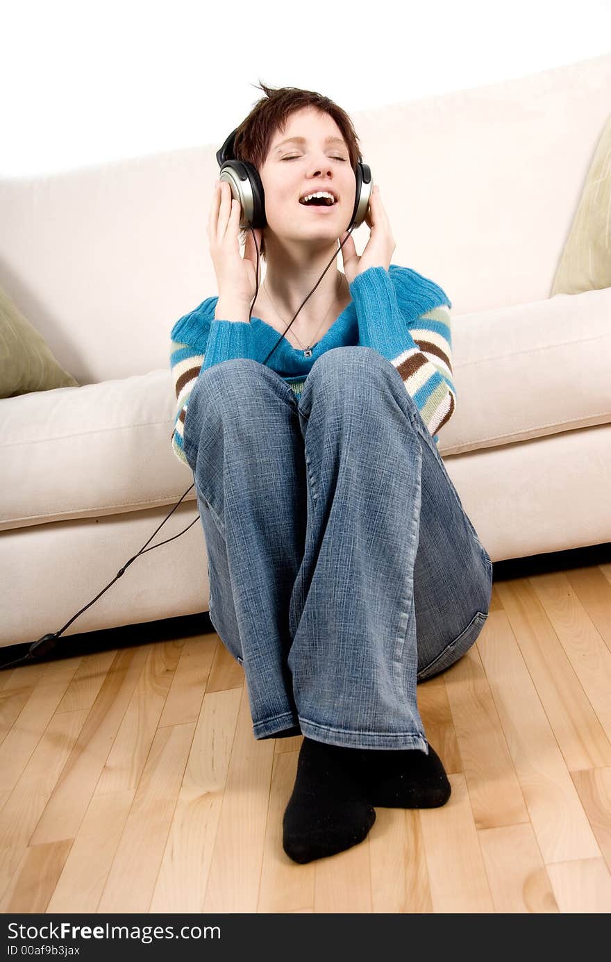 Cute girl with headphone happy lying on the couch. Cute girl with headphone happy lying on the couch