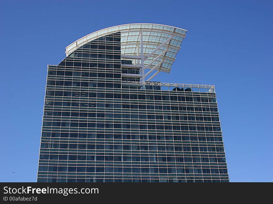 Modern Blue Glass building with curved roof against sky