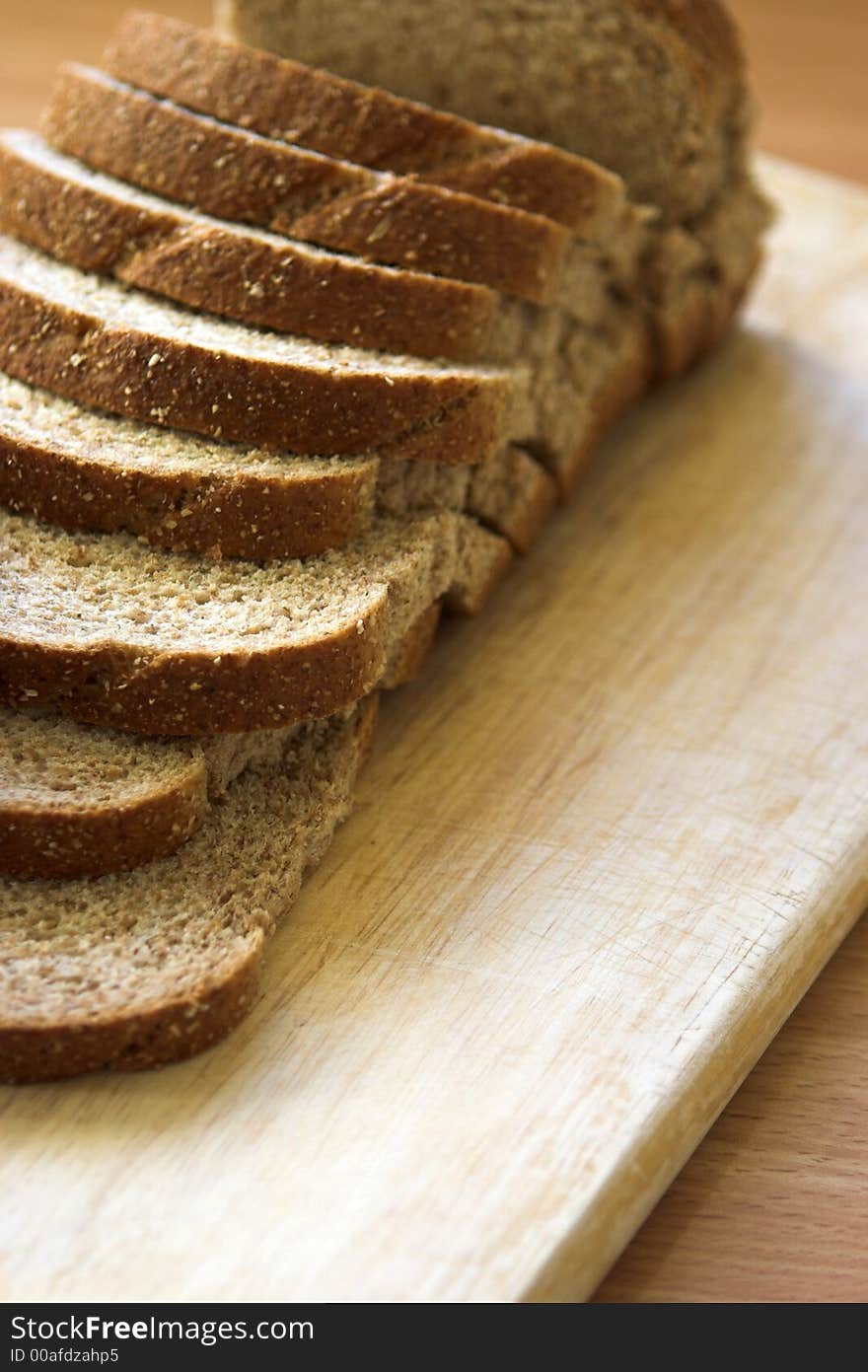 Sliced wholemeal bread arranged on a chopping board - shallow depth of field. Sliced wholemeal bread arranged on a chopping board - shallow depth of field