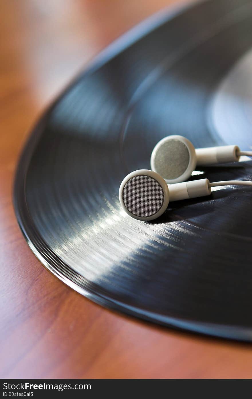 Close up of white headphones on a vinyl record - shallow dof. Close up of white headphones on a vinyl record - shallow dof