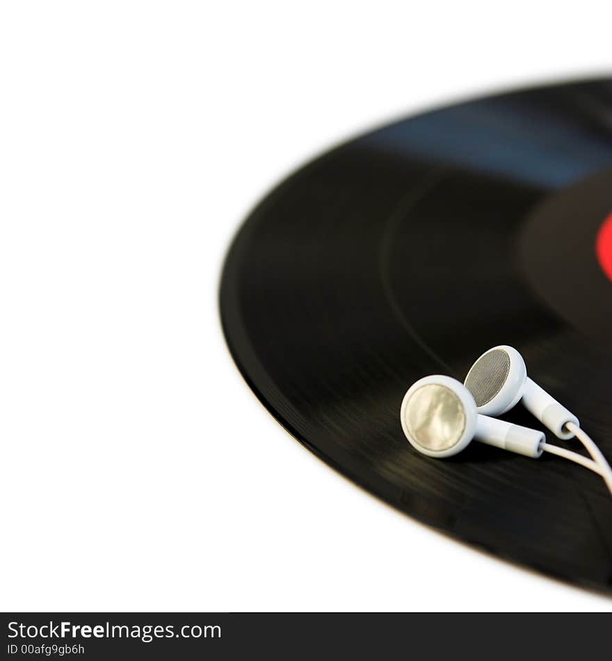 Close up of white headphones on a vinyl record with copy space to the left - shallow dof. Close up of white headphones on a vinyl record with copy space to the left - shallow dof