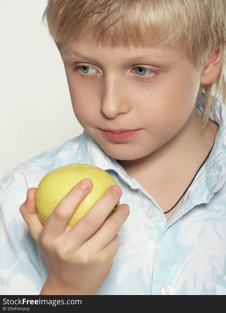 An eleven-year boy eats an apple. On white background. An eleven-year boy eats an apple. On white background.