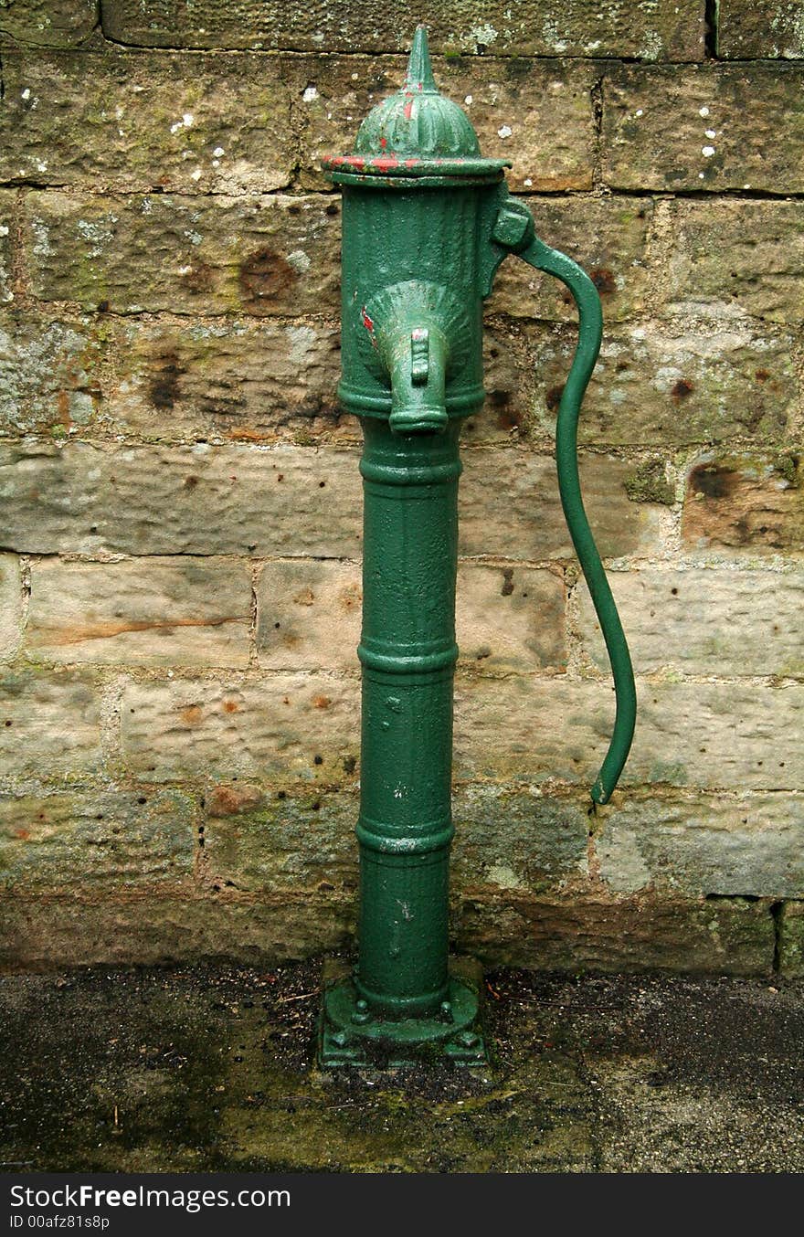 Green painted old wwater pump which would bring water from a souce in the ground. Green painted old wwater pump which would bring water from a souce in the ground