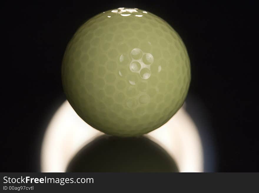 Picture of yellow golf ball backlight on glass