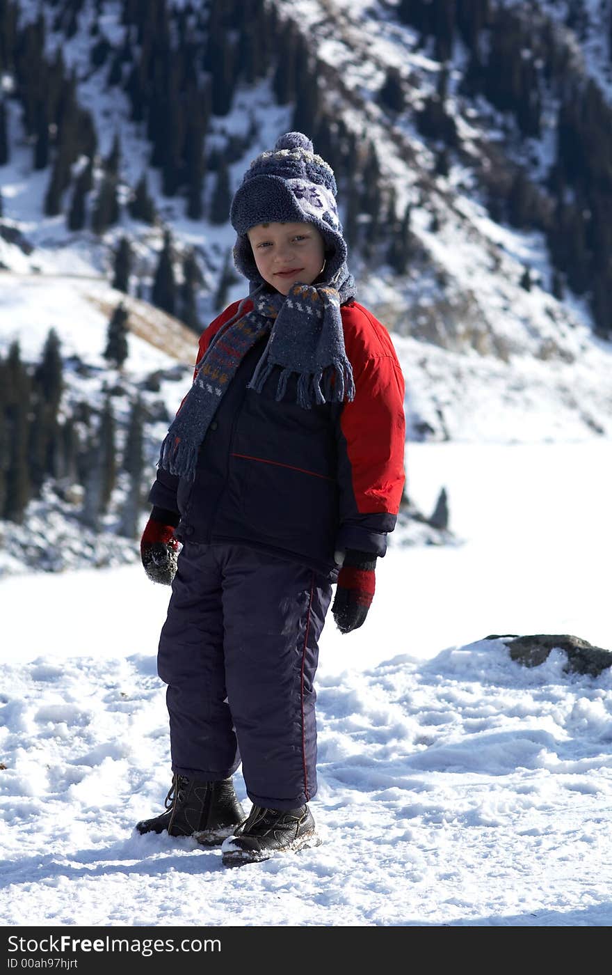 Boy and winter mountains - walk beside mountain lake