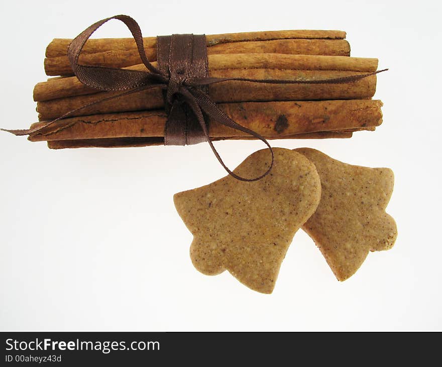 Gingerbreads in a bell shape and two sicks  of  cinnamon. Gingerbreads in a bell shape and two sicks  of  cinnamon