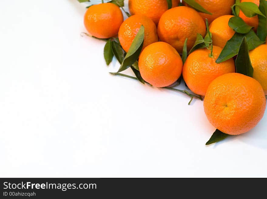 A pile of orange tangerine brancheswith green leaf on white background. A pile of orange tangerine brancheswith green leaf on white background