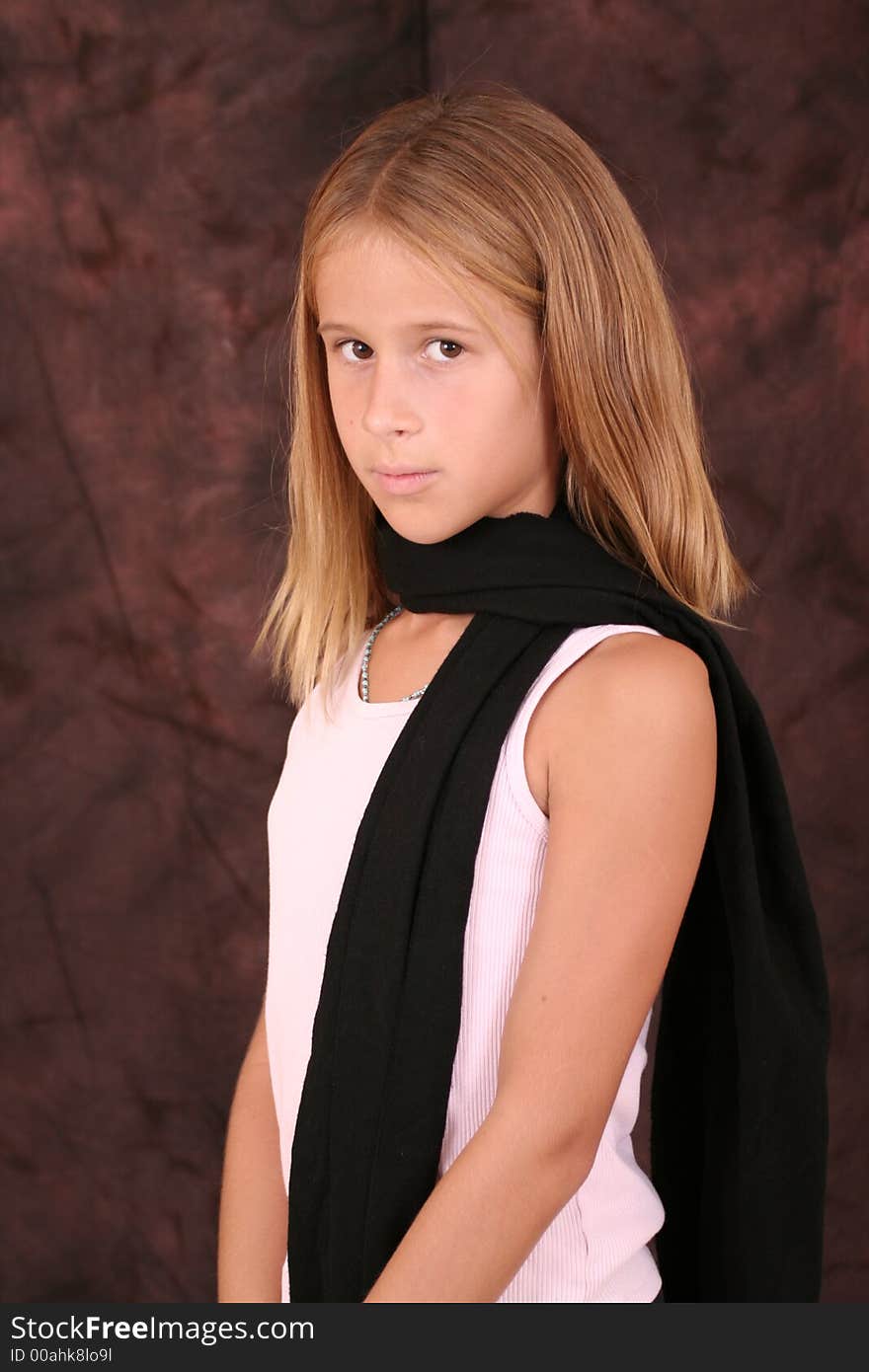 A young girl poses for photo wearing a scarf. A young girl poses for photo wearing a scarf