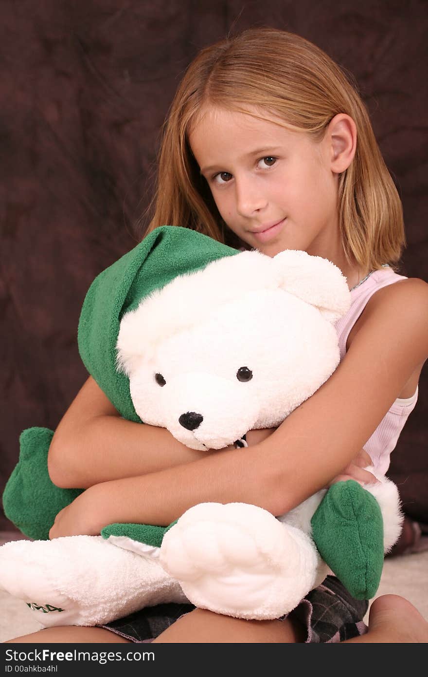 Young girl hugs a Christmas teddy bear. Young girl hugs a Christmas teddy bear