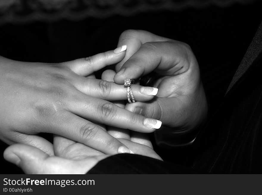 Groom places ring on brides finger. Groom places ring on brides finger