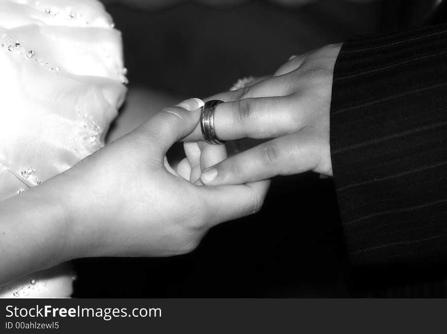 Bride places ring on grooms finger. Bride places ring on grooms finger