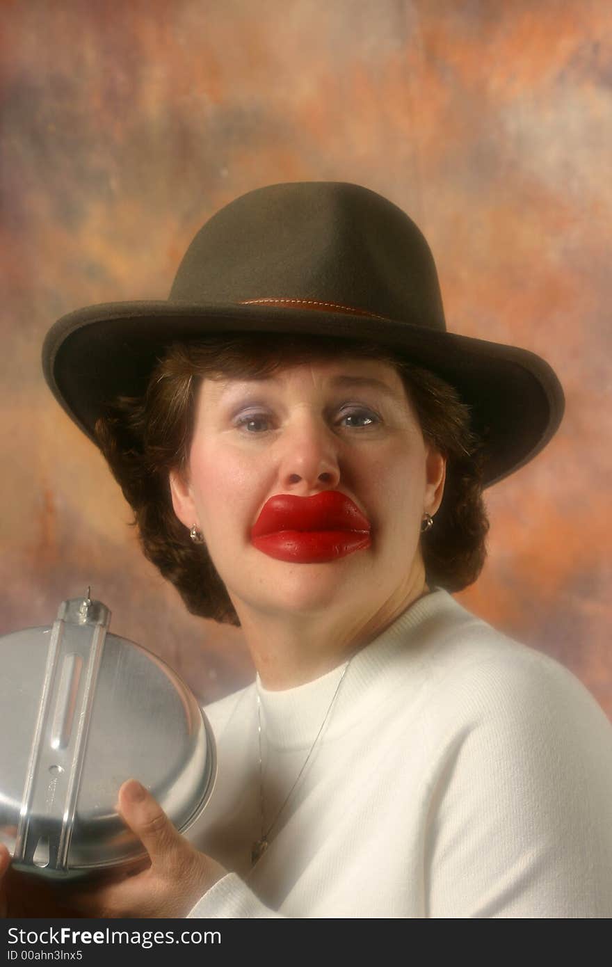 Lady wears big red wax lips and cowboy hat. Lady wears big red wax lips and cowboy hat