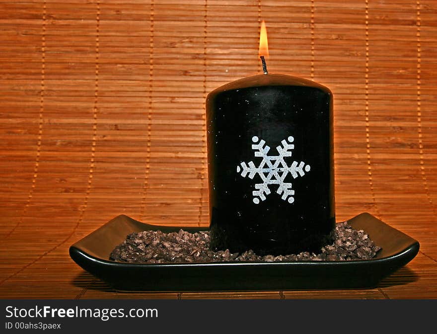 Christmas candle on a bamboo background