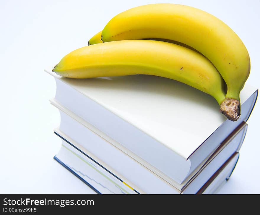 Books and bananas isolated over white background