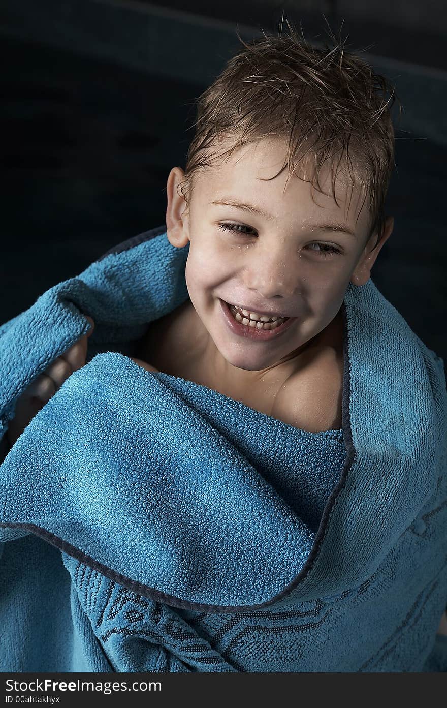 Smiling small boy with blue towel in swimming pool. Smiling small boy with blue towel in swimming pool