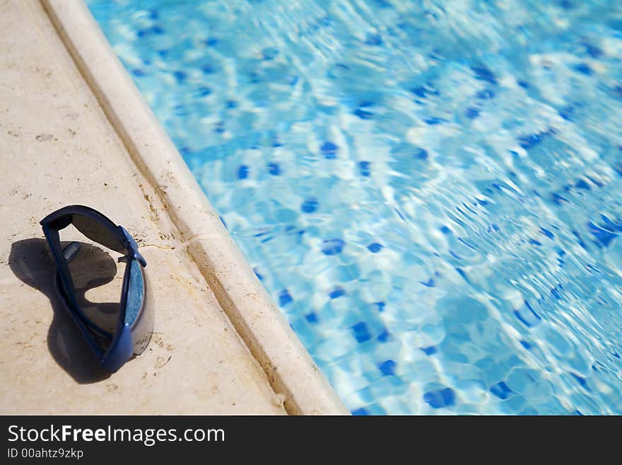 Glasses on a  swimming-pool edge