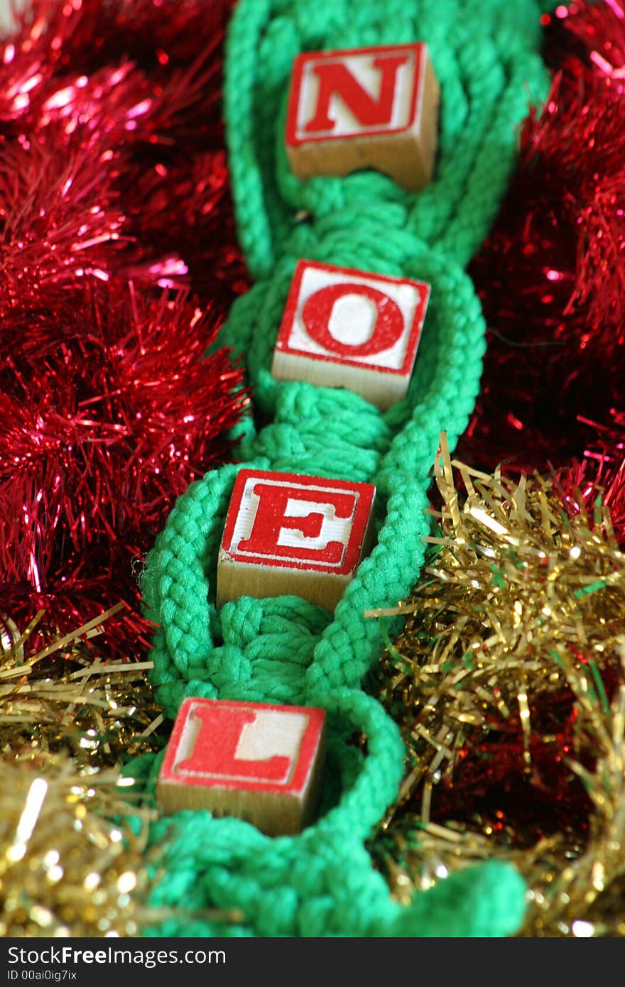 Shot of NOEL in Red & Gold tinsel background