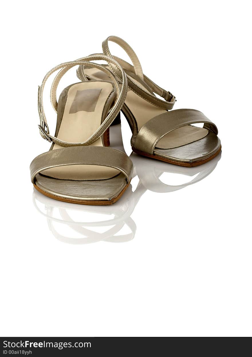 Beautiful feminine sandals on white with reflection