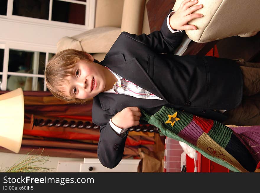 Boy holding a christmas stocking in a living room. Boy holding a christmas stocking in a living room