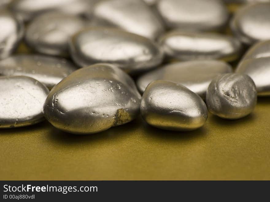 Silver painted stones set against a gold background.