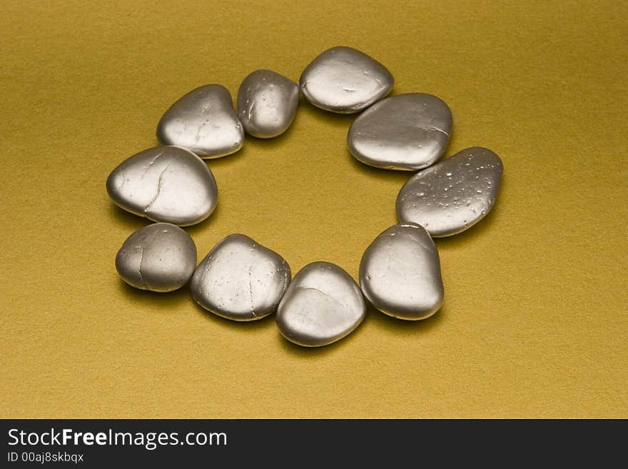 Silver painted stones set against a gold background.