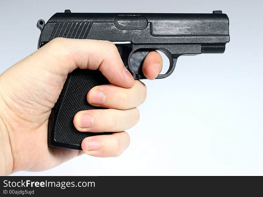 Front view for black gun in hand isolated on light background